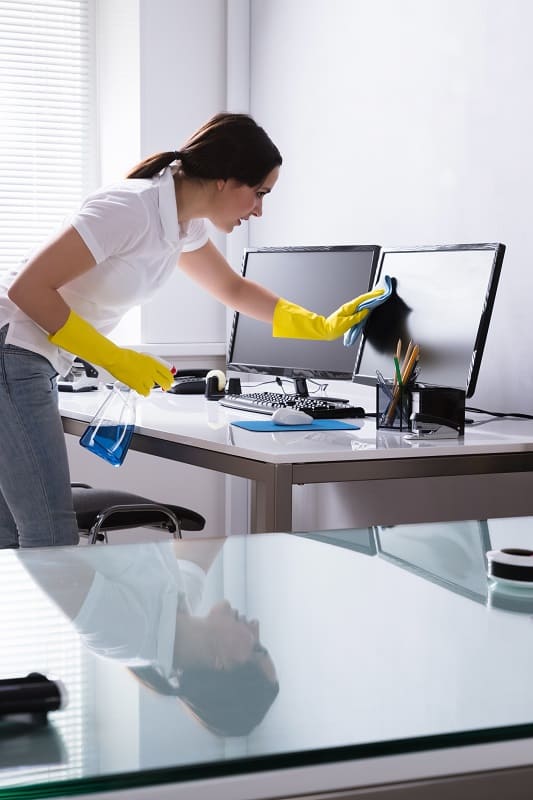 Woman cleaning a computer screen