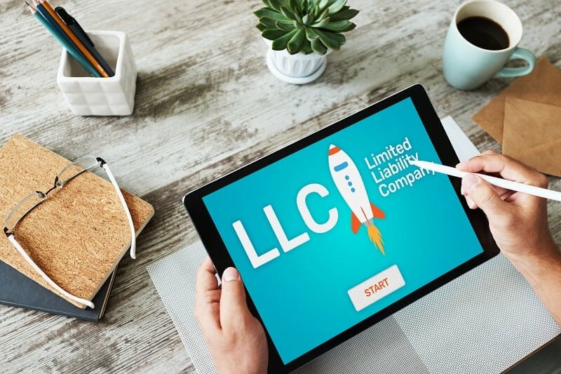 Person looking at a tablet that has an LLC graphic on it