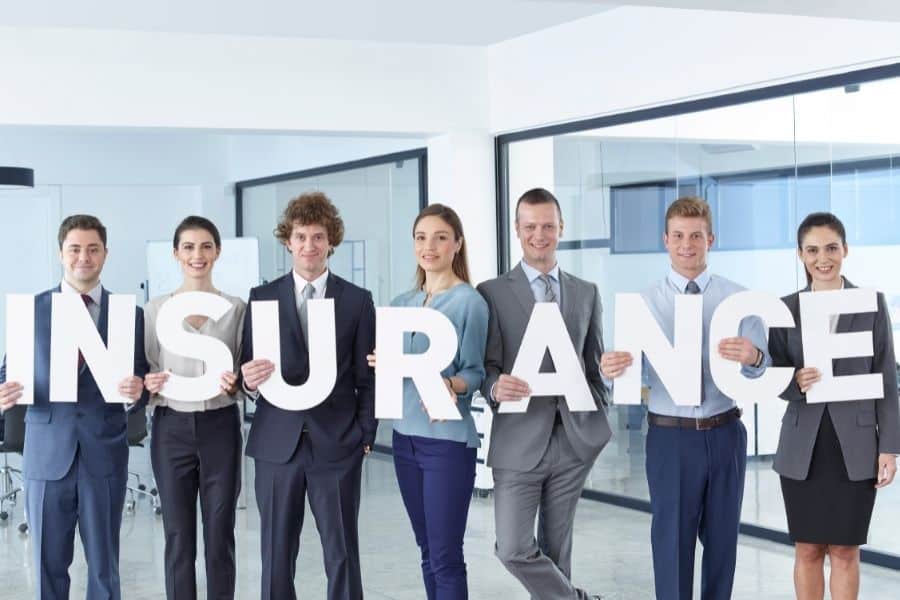 Business men and business women standing in office and holding letters insurance