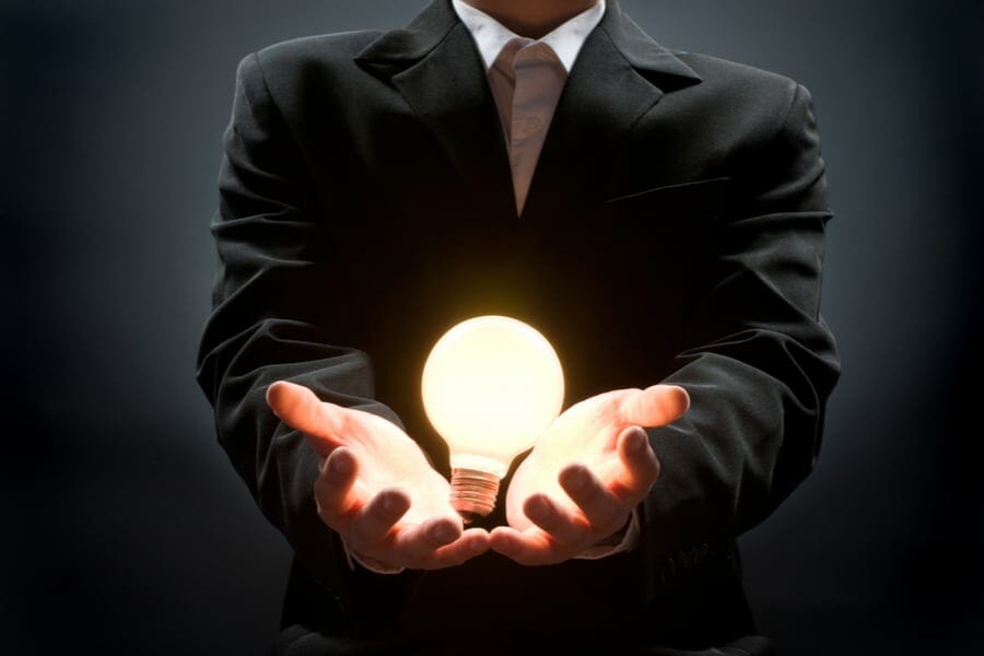a man pointing to the illuminated bulb
