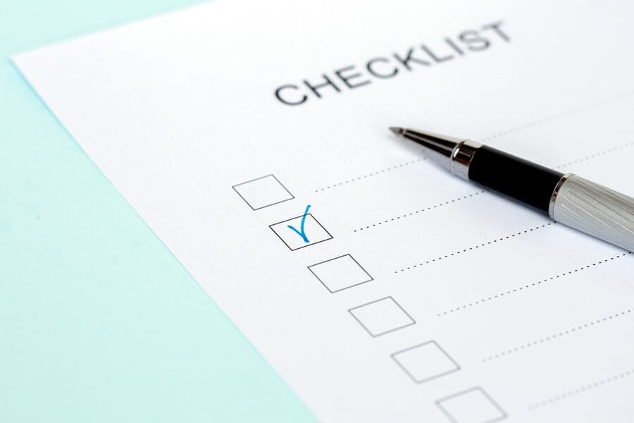 Close-up of on Checklist with pen on a blue background.