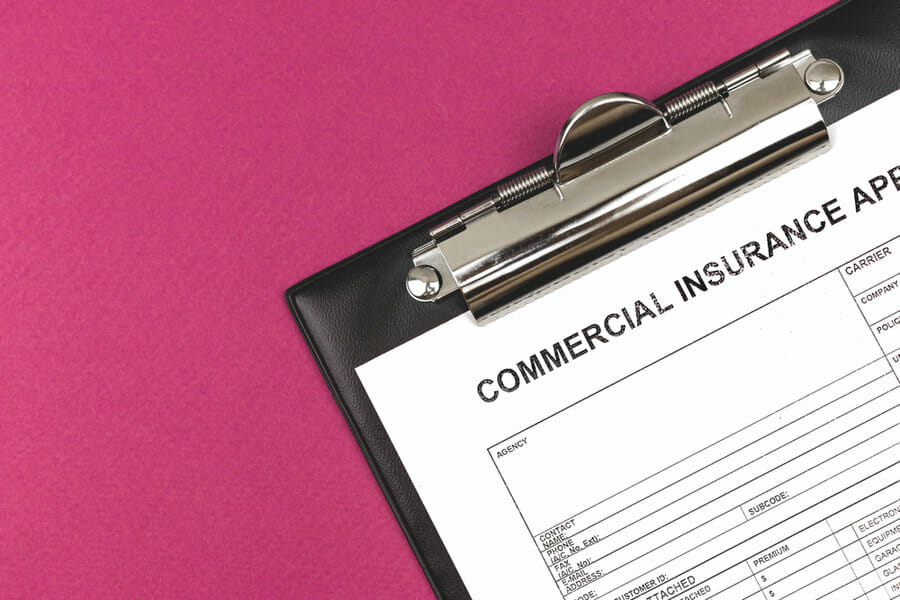Commercial insurance application. Clipboard on a business desktop. Top view and copy space