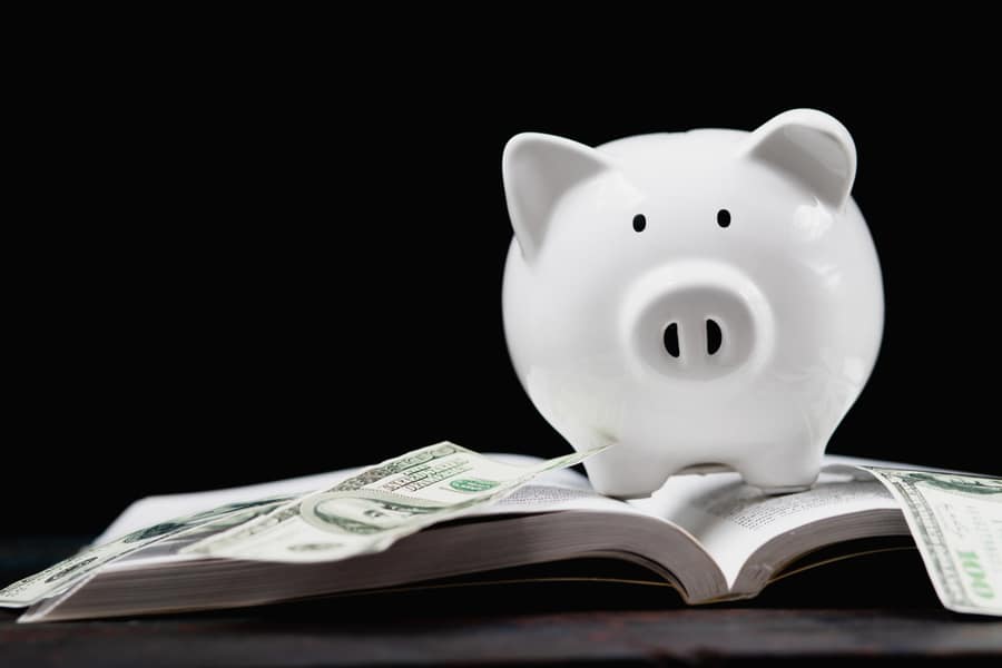 Investing for education, piggy bank piggy bank placed on the textbook, the idea of ​​saving money for education.