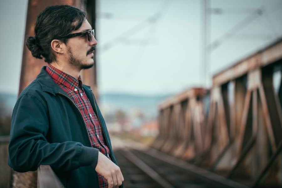 Modern bearded hipster standing on the railway bridge in spring.