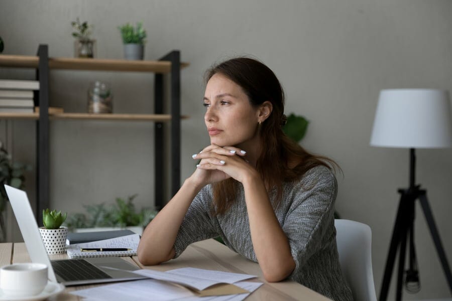 Pensive young Caucasian woman distracted form computer work read letter thinking pondering of problem. Thoughtful millennial female receive unpleasant news in document paperwork, make decision