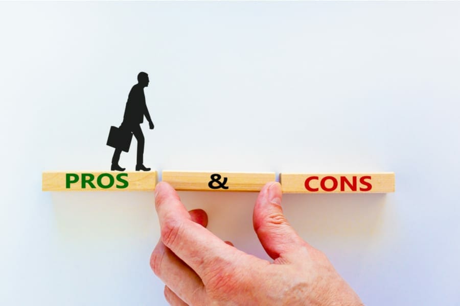 Pros and cons symbol. Wooden blocks with words 'Pros and cons'. Beautiful white background, businessman hand, businessman icon. Business, pros and cons concept, copy space.