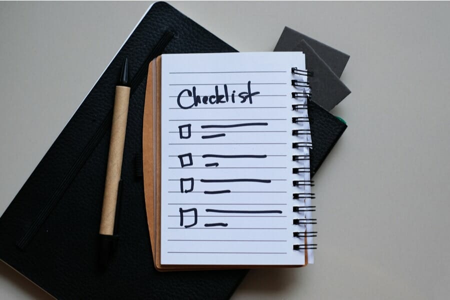 Close-up of on Checklist with pen on notebook.
