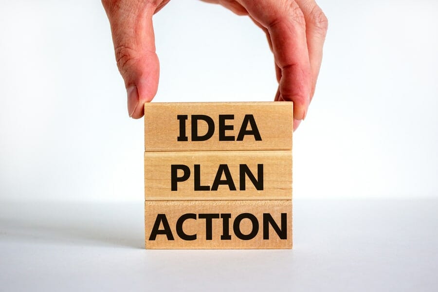 Idea, plan, action symbol. Wooden blocks form the words 'Idea, plan, action' on beautiful white background. Businessman hand. Business, idea, plan, action concept. Copy space.