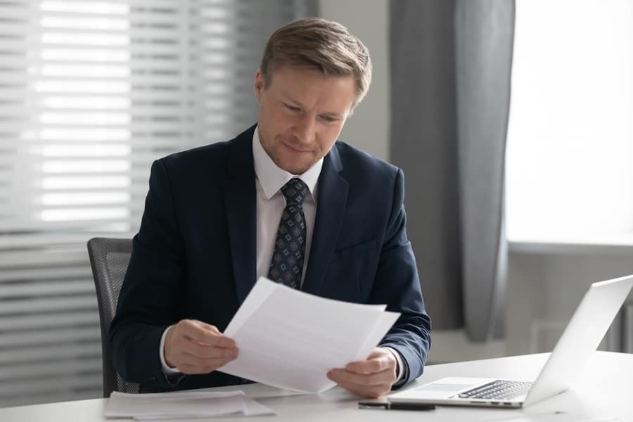 business man in suit reading document paper