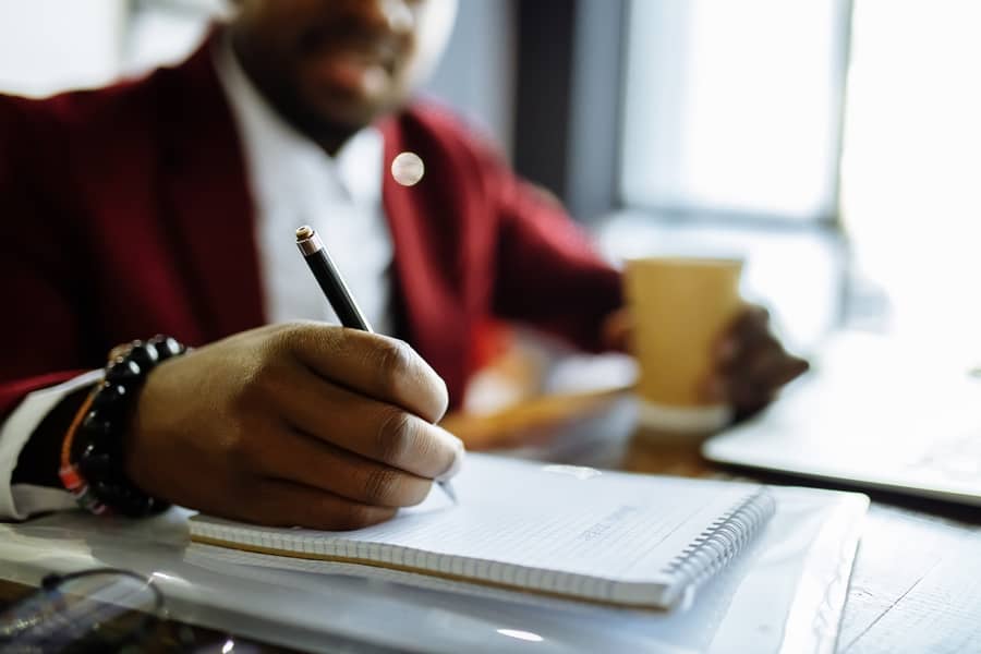 man writing on document