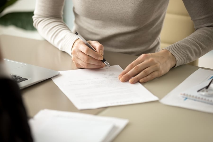 woman signing document in the office table