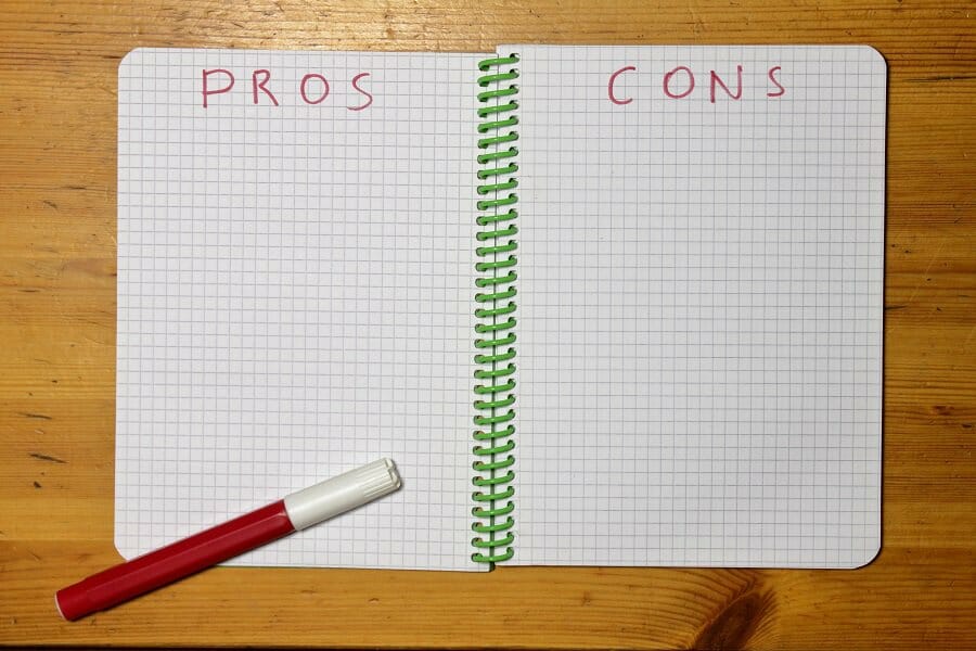 pros and cons list in a notebook with red marker