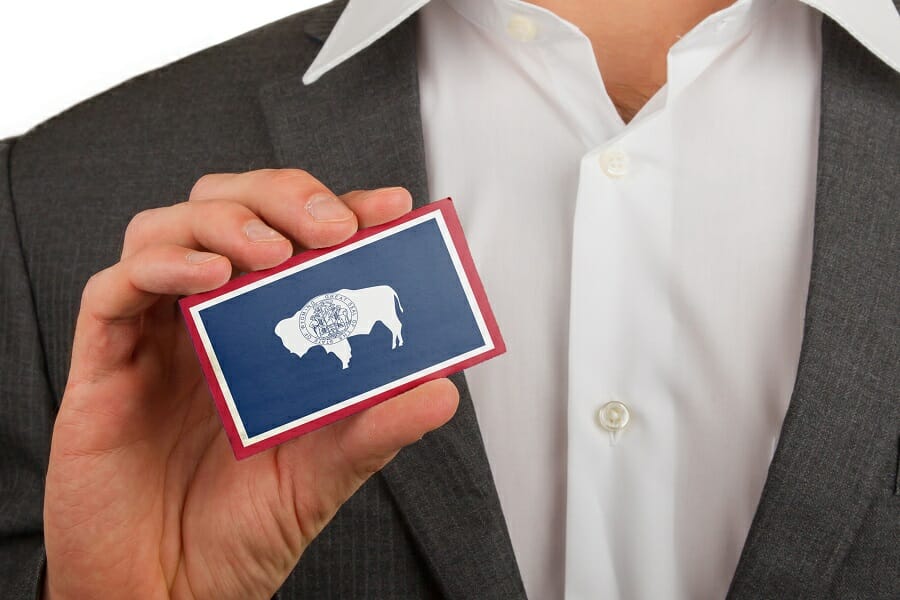 businessman holding a business card with wyoming flag