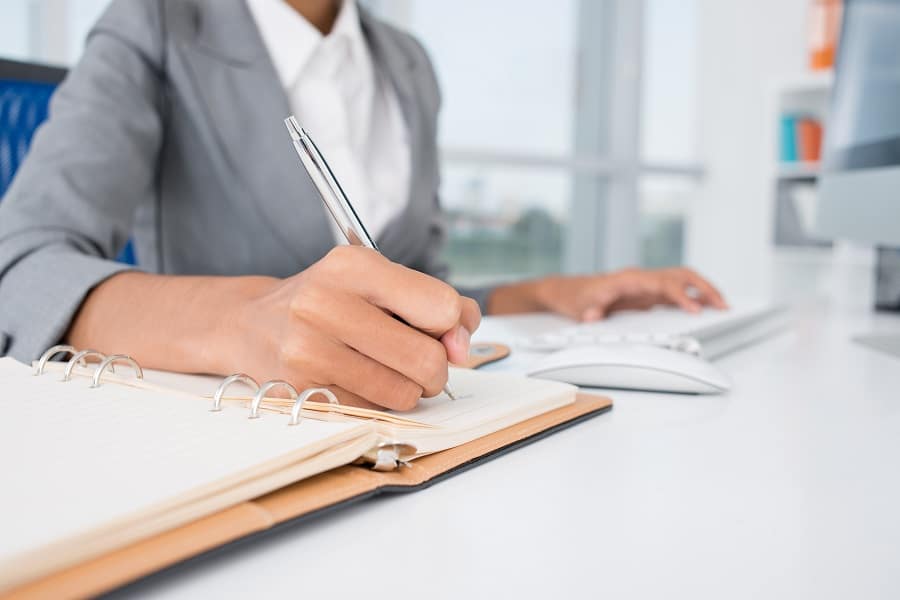 businesswoman writing on notebooks for reports