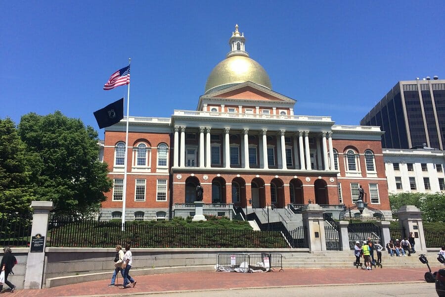 statehouse of massachusetts with american flag