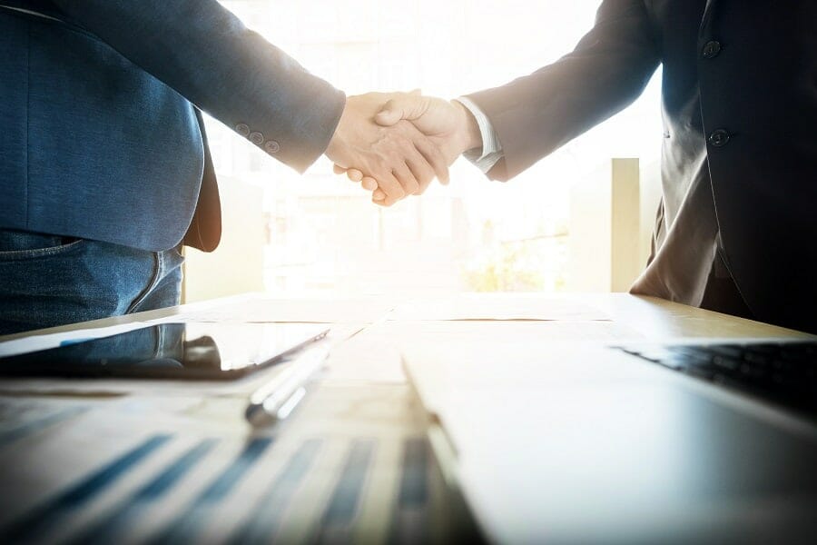 two businessmen shaking hands during meeting