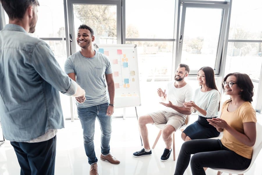 coworkers applauding for his prosperous project