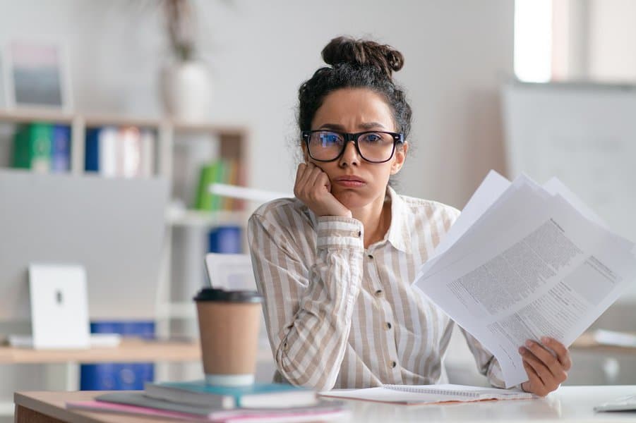 unhappy businesswoman working on paper work